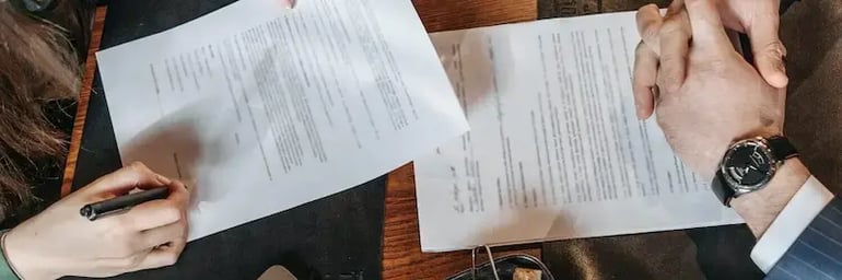 Two people signing a lease contract for a commercial space